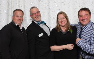 NorthAmericaTalk CEO Dan Jones (right) and VP of Sales Martin McElliott (left) celebrate an award with WhatcomTalk teammates Kevin Coleman (in bow tie) and Stacee Sledge.
